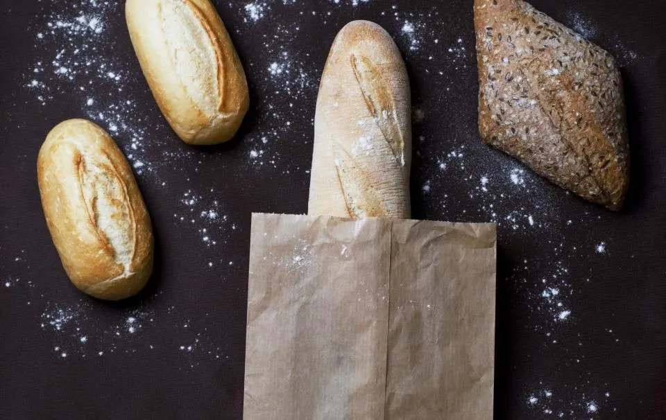 Baguettes et petits pains sur un plan de travail fariné